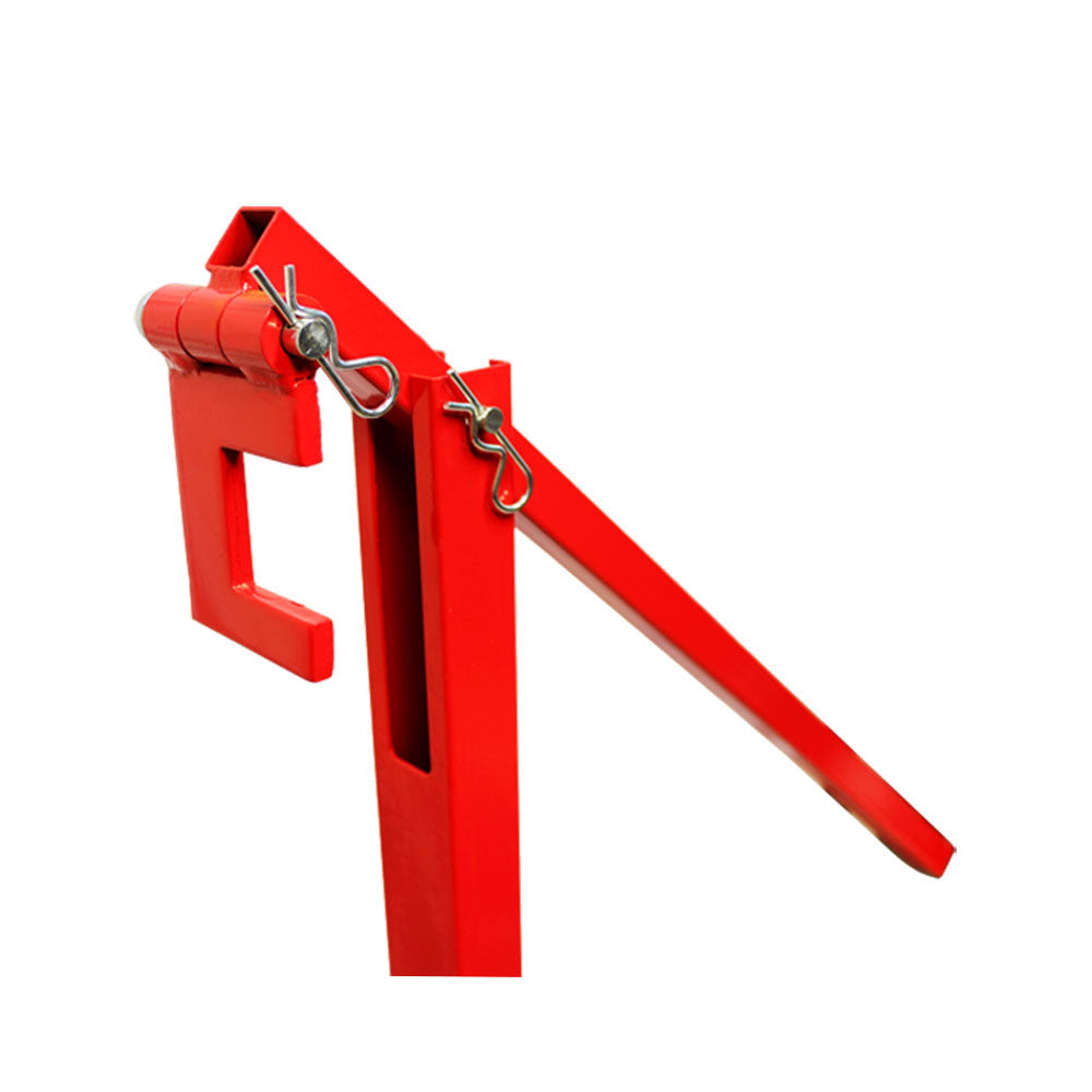 Close-up of red fence post puller tool with hinge and pin assembly for post removal.